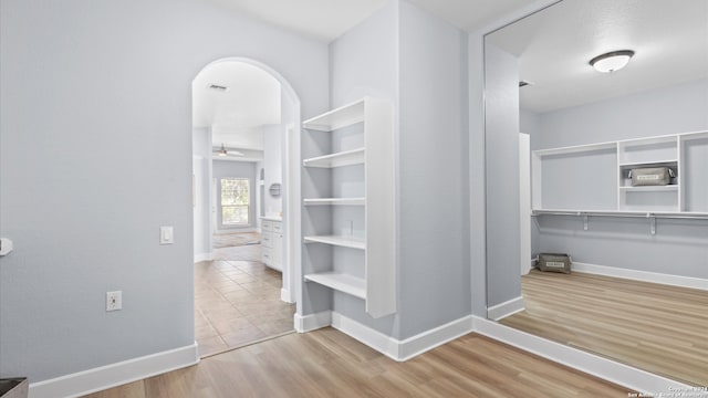 spacious closet featuring light hardwood / wood-style floors and ceiling fan