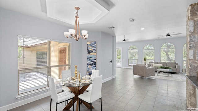 tiled dining area featuring ceiling fan with notable chandelier