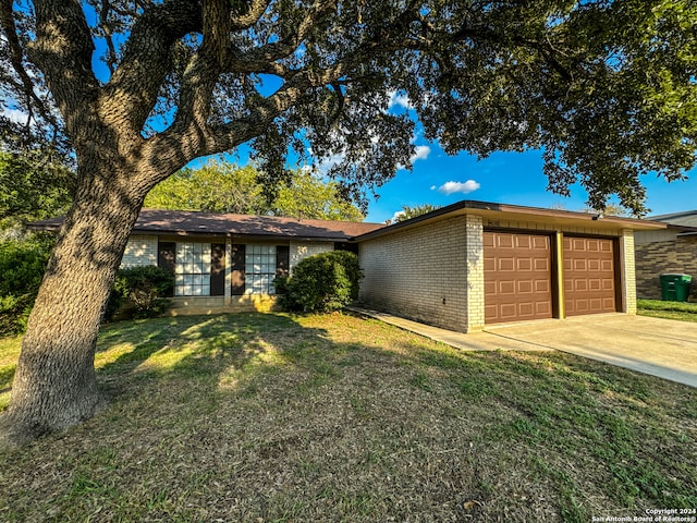 single story home featuring a front lawn and a garage