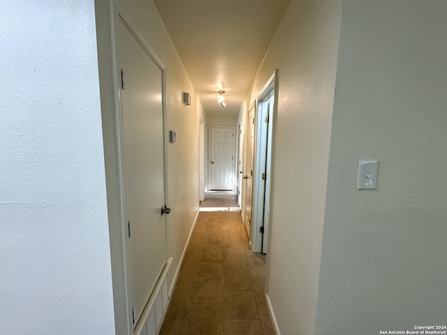 corridor featuring dark tile patterned flooring