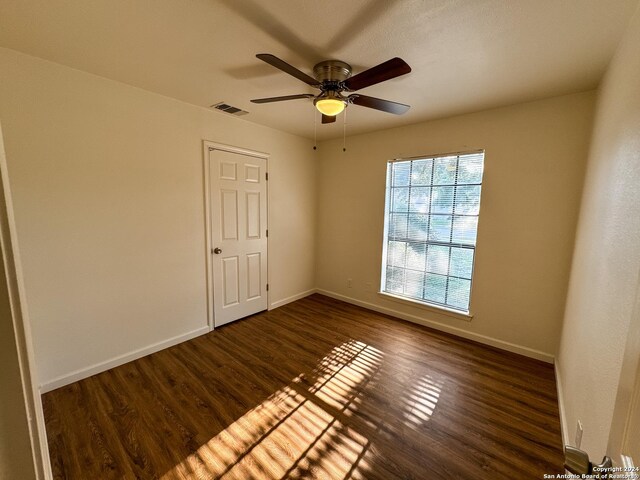 spare room featuring ceiling fan and dark hardwood / wood-style floors