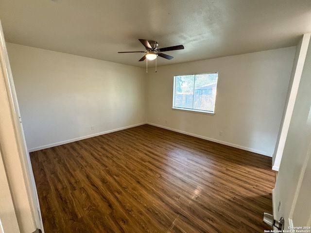 spare room featuring dark wood-type flooring and ceiling fan