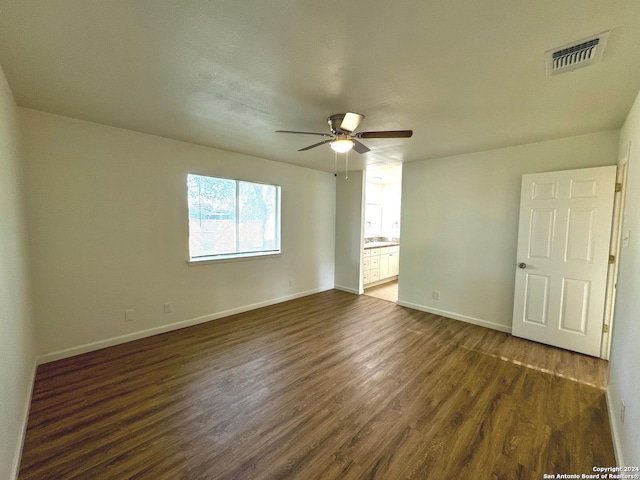 unfurnished room with ceiling fan and dark hardwood / wood-style flooring