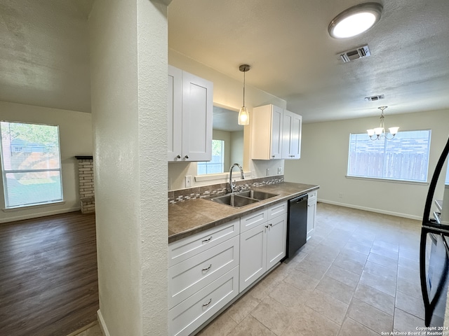 kitchen featuring an inviting chandelier, decorative light fixtures, dishwasher, sink, and white cabinetry