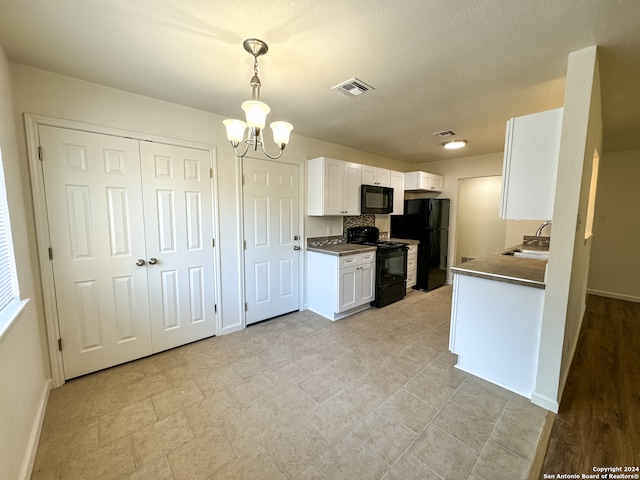 kitchen featuring black appliances, pendant lighting, a chandelier, and white cabinetry