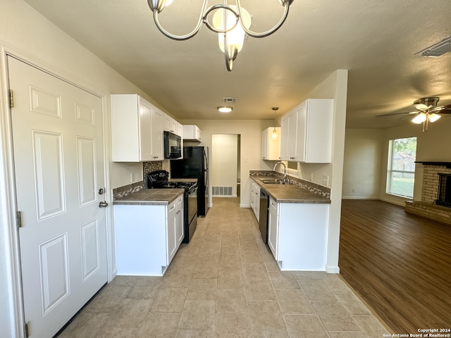 kitchen featuring light wood-type flooring, black appliances, ceiling fan with notable chandelier, and white cabinetry