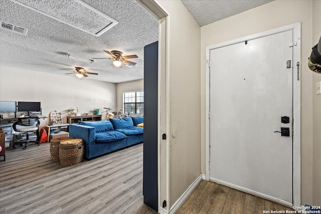 entryway with a textured ceiling, ceiling fan, and hardwood / wood-style flooring