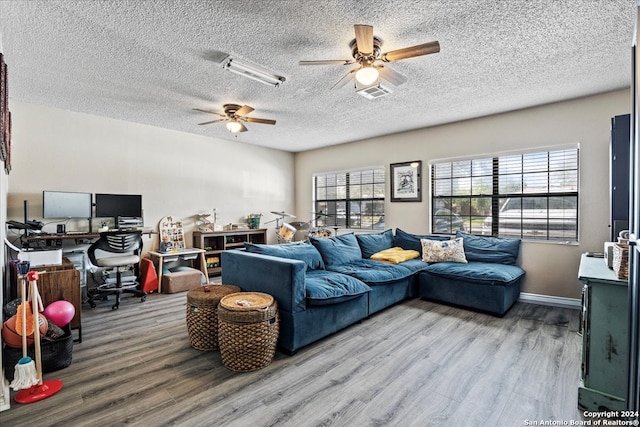 living room featuring light wood-type flooring, a textured ceiling, and ceiling fan