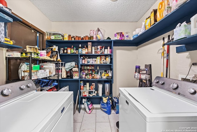 clothes washing area featuring washer and clothes dryer and a textured ceiling