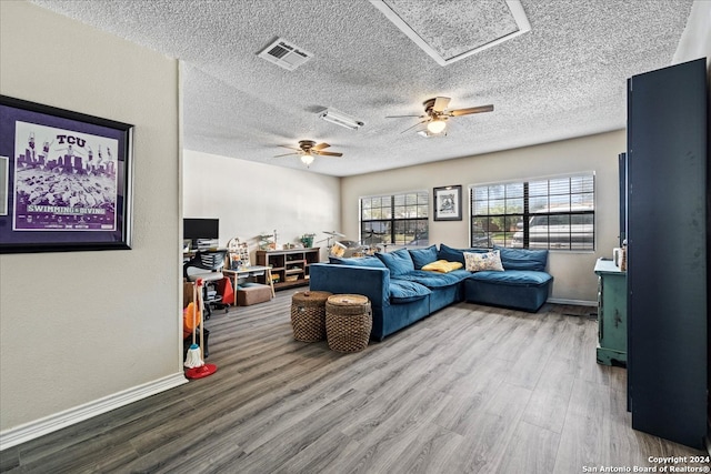 living room with a textured ceiling, wood-type flooring, and ceiling fan