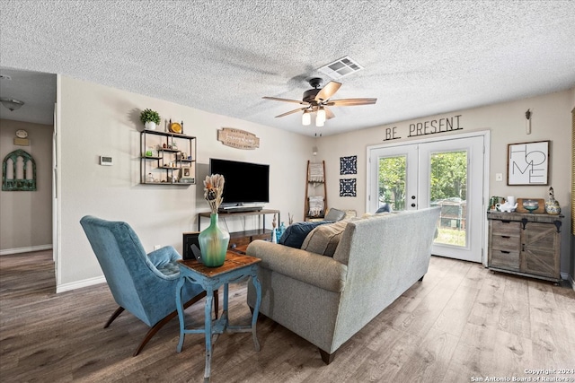 living room featuring french doors, a textured ceiling, hardwood / wood-style floors, and ceiling fan