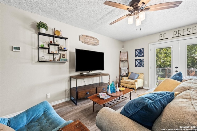 living room with french doors, a textured ceiling, wood-type flooring, and ceiling fan