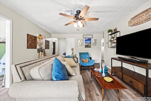 living room featuring a textured ceiling, hardwood / wood-style floors, and ceiling fan