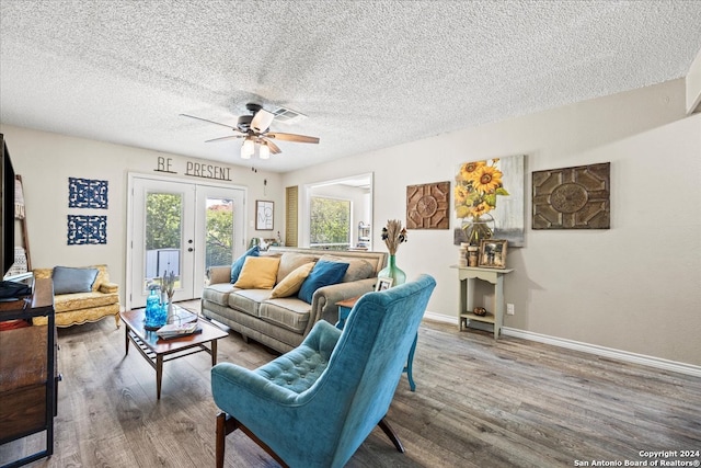 living room with french doors, a textured ceiling, hardwood / wood-style flooring, and ceiling fan