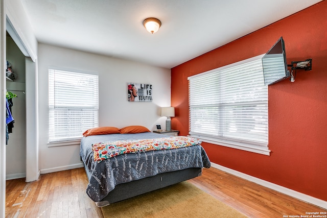 bedroom featuring multiple windows and hardwood / wood-style floors