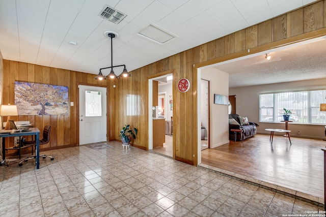 entrance foyer with light wood-type flooring and wooden walls