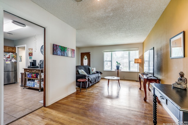 living area with a textured ceiling and light hardwood / wood-style flooring