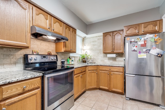 kitchen featuring backsplash, stainless steel appliances, sink, light stone countertops, and light tile patterned flooring