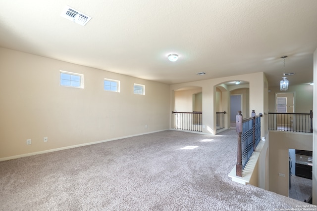 unfurnished room with a textured ceiling, carpet floors, and a fireplace