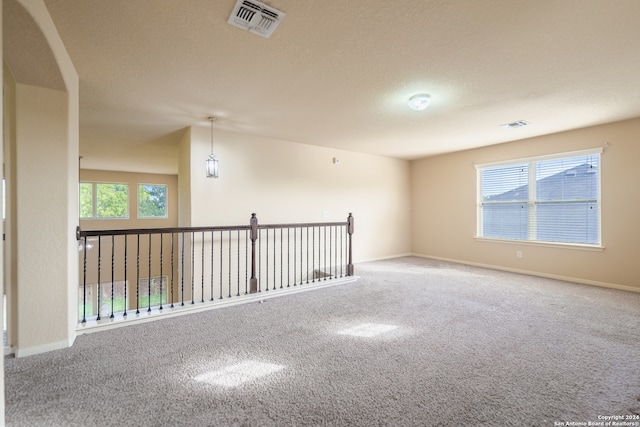 spare room featuring a textured ceiling and carpet