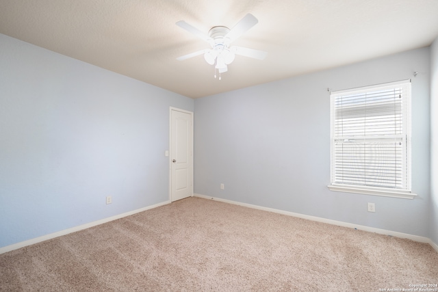 spare room featuring ceiling fan and carpet