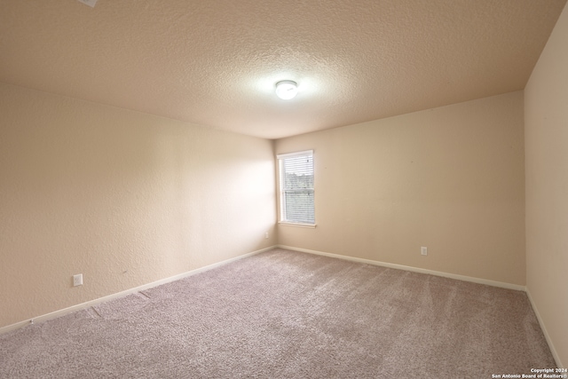 carpeted empty room with a textured ceiling