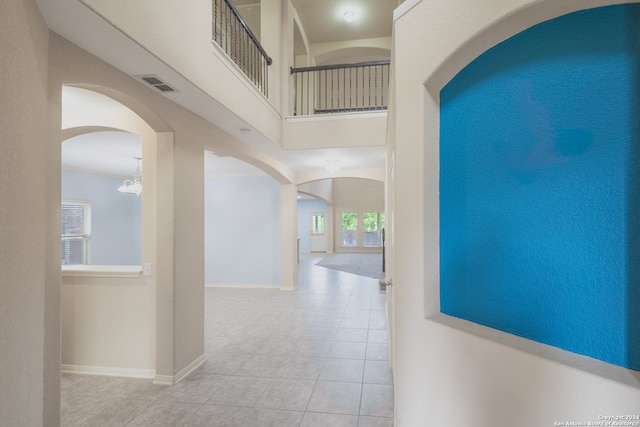 hallway featuring light tile patterned floors and a chandelier