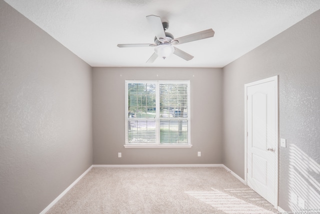 unfurnished room featuring light carpet and ceiling fan