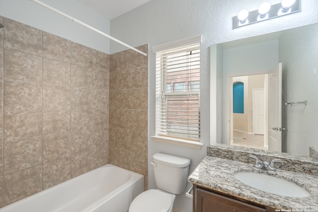 full bathroom featuring toilet, tiled shower / bath combo, and vanity