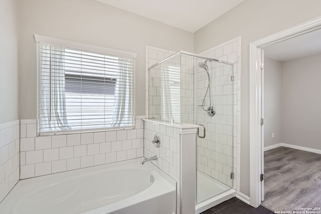 bathroom with hardwood / wood-style floors and separate shower and tub