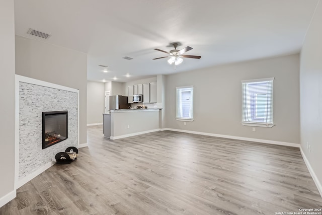 unfurnished living room featuring light wood-type flooring and ceiling fan