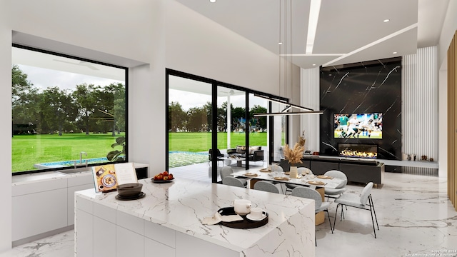 interior space with a premium fireplace, light stone countertops, and white cabinets