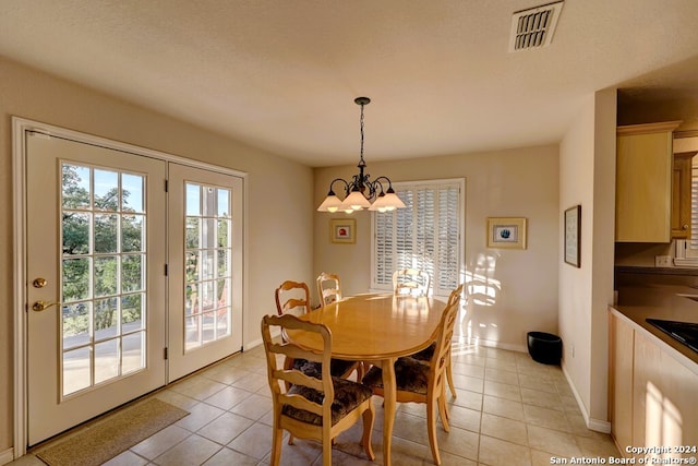 dining room featuring a chandelier, a textured ceiling, and light tile patterned flooring