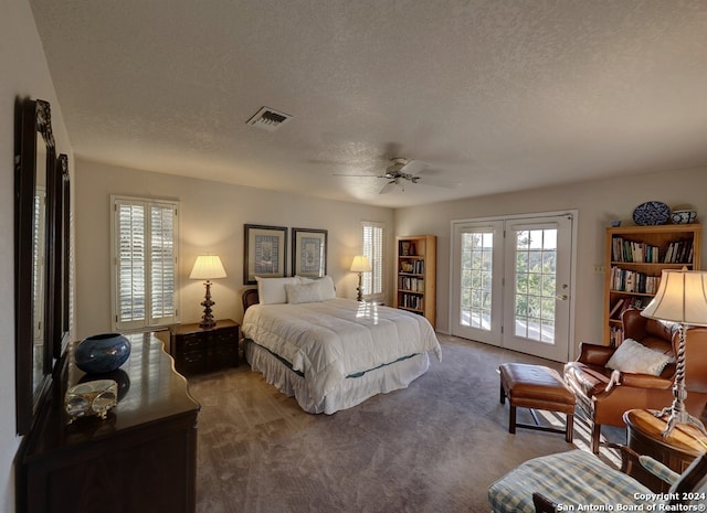 carpeted bedroom with a textured ceiling, access to exterior, and ceiling fan