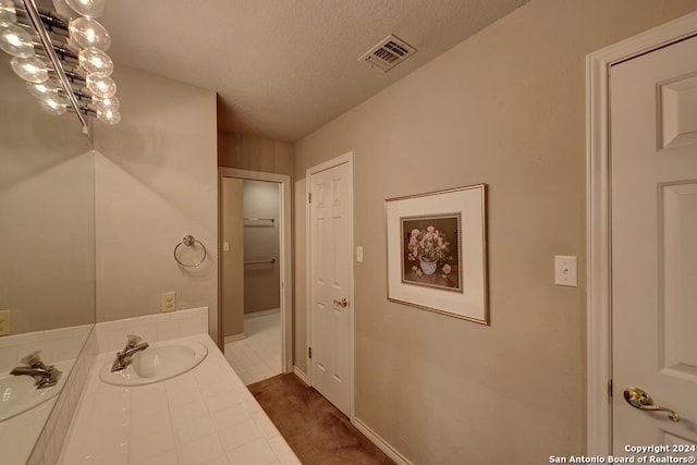 bathroom featuring tile patterned flooring, vanity, and a textured ceiling