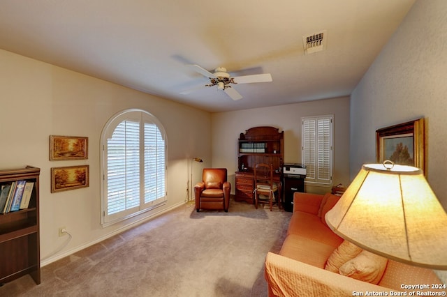 living area featuring carpet and ceiling fan