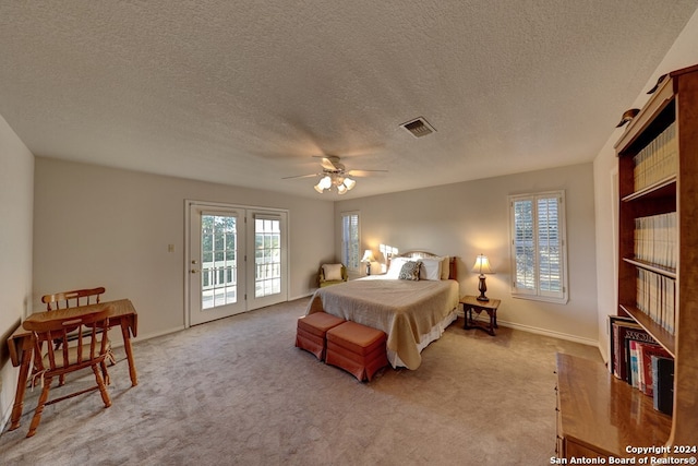 carpeted bedroom with a textured ceiling, access to exterior, and ceiling fan