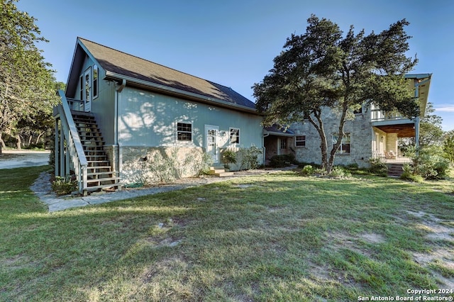 rear view of house featuring a lawn