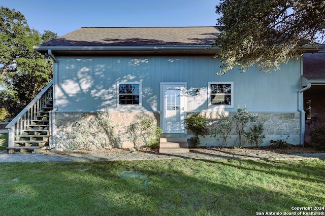 rear view of house featuring a yard