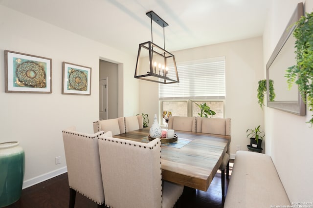 dining space featuring dark hardwood / wood-style floors and an inviting chandelier