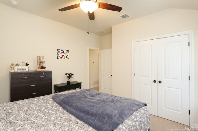 carpeted bedroom with vaulted ceiling, a closet, and ceiling fan