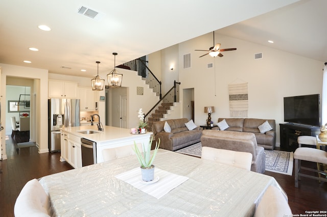 dining room featuring sink, ceiling fan with notable chandelier, high vaulted ceiling, and dark hardwood / wood-style flooring