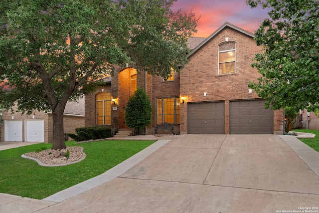 front of property with a garage and a lawn