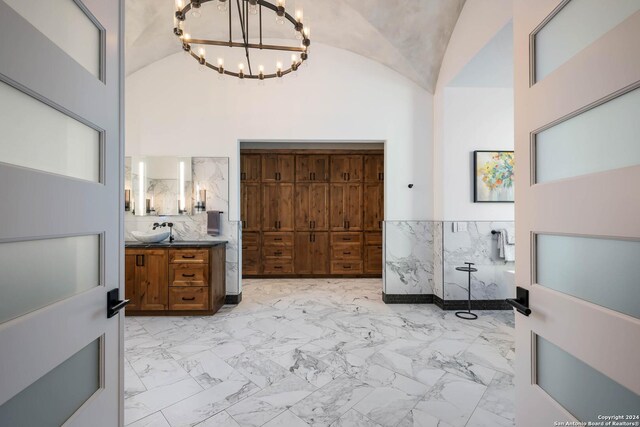 interior space featuring high vaulted ceiling, a chandelier, and sink