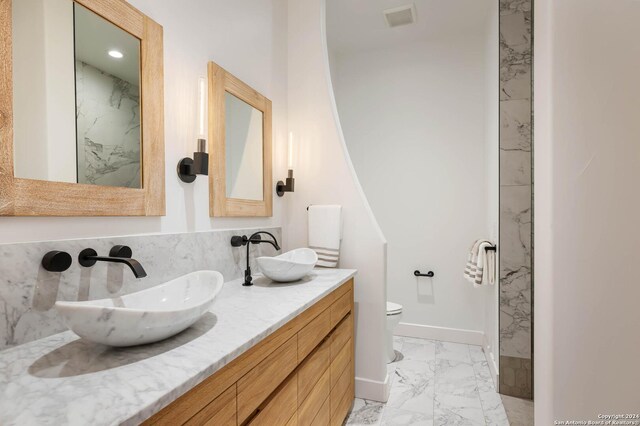 bathroom with a shower with door, vanity, and toilet