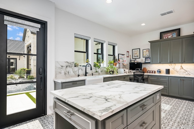 kitchen with gray cabinets, plenty of natural light, and sink