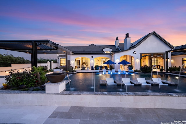 pool at dusk featuring a patio