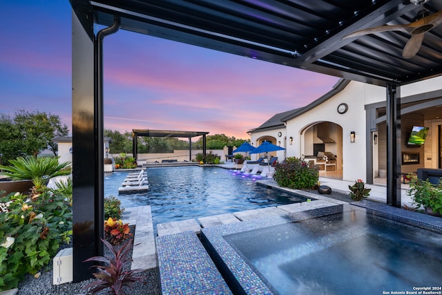 view of swimming pool with pool water feature, ceiling fan, and a patio