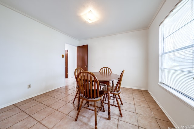 dining room featuring ornamental molding and light tile patterned flooring