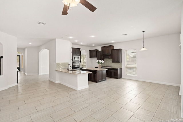 kitchen featuring backsplash, dark brown cabinets, kitchen peninsula, and stainless steel appliances